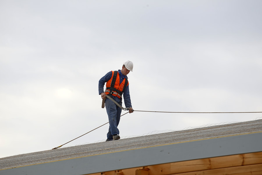 man walking on the roof with a safety harness 